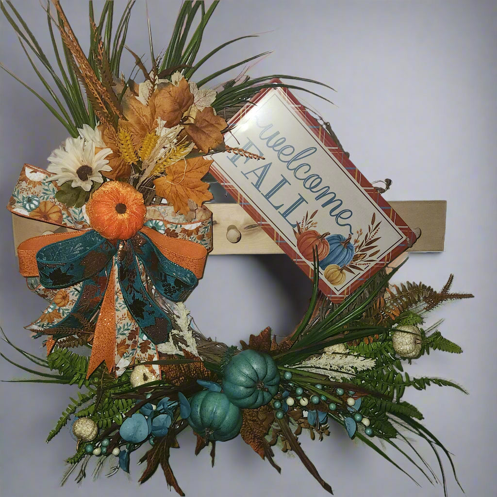 Decorative wreath with autumnal elements in turquoise and orange.